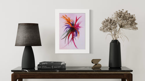 Framed abstract artwork on a wall above a table with decorative items.